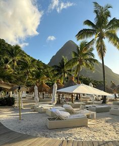 the beach is lined with lounge chairs and umbrellas