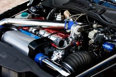 the engine compartment of a sports car with its hood open and it's exhaust system exposed