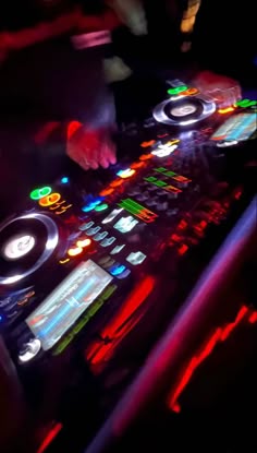 a dj playing music on his turntable in the dark
