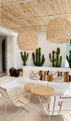 a living room filled with lots of furniture next to cactus plants and potted plants
