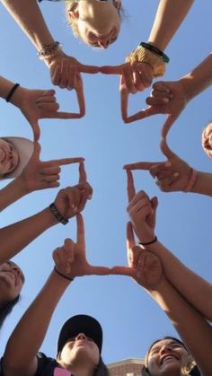 a group of people standing in a circle holding their hands together and making the shape of a star