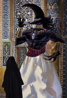 a woman's dress and headdress are displayed in front of an ornate wall