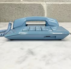an old blue phone sitting on top of a table