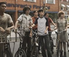 a group of young men standing next to each other on bicycles
