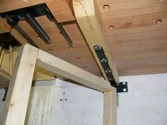 an unfinished room with wooden beams and brackets on the ceiling