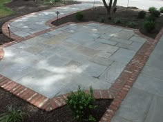 an outdoor patio with brick edging and landscaping