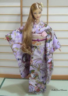 a doll with long hair wearing a purple kimono