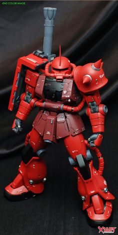 a red robot standing on top of a black surface