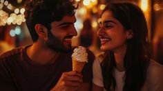 a man and woman eating an ice cream cone in front of them at night time