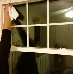 a person is cleaning windows with a rag