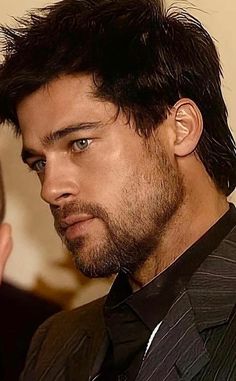 a close up of a person wearing a suit and tie with hair in the air