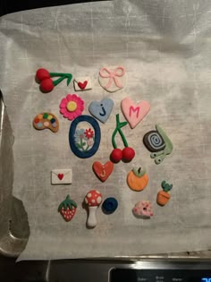 the cookies are decorated with different designs and colors on the cookie sheet that is baking