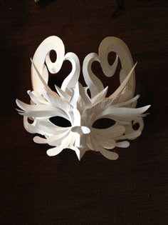 a mask made out of white paper with hearts on it