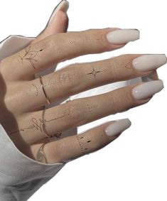 a woman's hand with tattoos on her fingers and fingernails in the shape of stars