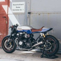 a blue and white motorcycle parked in front of a building