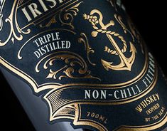 a close up of a bottle of wine with gold lettering on the top and bottom
