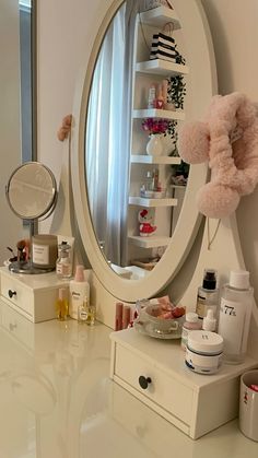a vanity with an oval mirror and pink teddy bear