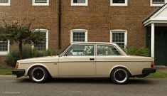 an old car parked in front of a brick building