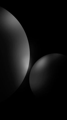 an abstract black and white photo with two oval objects in the middle, on a dark background