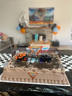 there is a cake that looks like a race track with cars on it and dirt in the middle