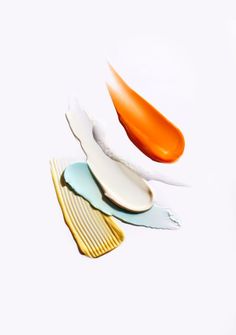 three orange and white knives are laying on top of each other in the same direction