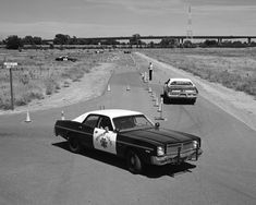 an old police car is parked on the side of the road