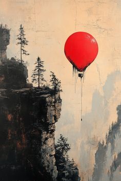 a red balloon flying over a mountain with trees