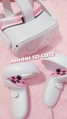 two white and pink controllers sitting on top of a pink carpet next to each other