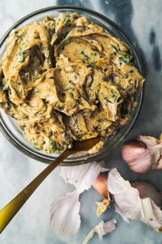 a glass bowl filled with food next to garlic