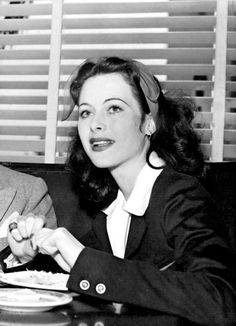 a man and woman sitting at a table in front of a plate of food with utensils