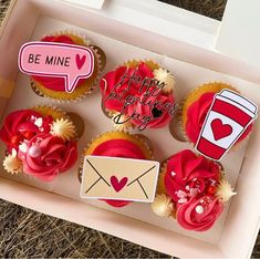 cupcakes decorated with red icing and decorations in a pink box that says be mine