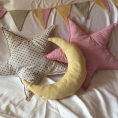 two pillows are laying on a bed next to a crescent and star shaped pillow with polka dots