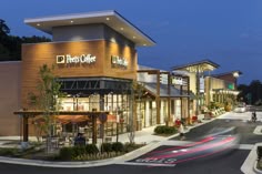 the exterior of a restaurant called pee's cafe at night with cars passing by