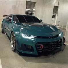 a blue chevrolet camaro is parked in a parking garage