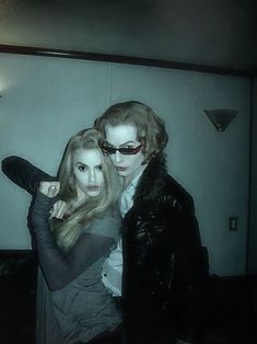 two people dressed up in costumes posing for a photo with their arms around each other
