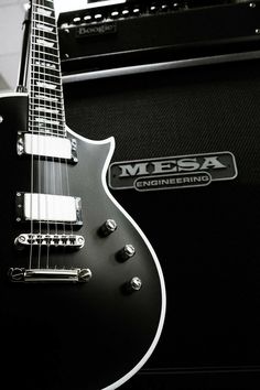 an electric guitar sitting on top of a black amp with the words mesa engineering written on it