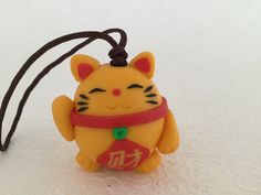 a small yellow cat keychain with chinese characters on it
