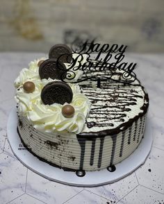 a birthday cake with oreo cookies and white frosting