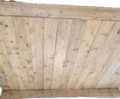 an unfinished wooden ceiling with planks on the top and bottom panel, showing woodgrain