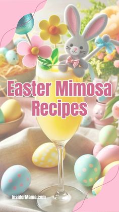 a glass filled with yellow liquid next to some decorated eggs and an easter bunny in the background