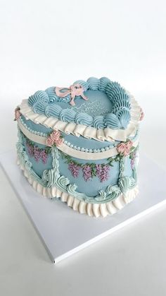 there is a blue cake with flowers on it