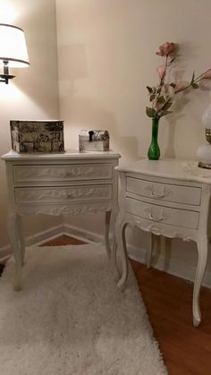 two white desks with flowers on them in a room next to a lamp and rug