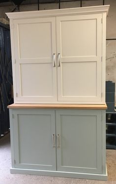 a large white cabinet with two doors and drawers