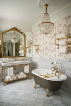a bathroom with a claw foot tub, chandelier and mirror