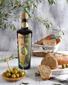 olives and bread on a table next to a bottle of olive oil