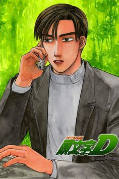 a man sitting at a desk with a laptop computer in front of him and holding a cell phone to his ear