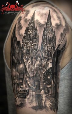 the back of a man's arm with a black and grey tattoo on it