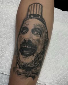 a close up of a person's arm with a clown tattoo on it