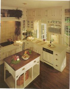 a large kitchen with white cabinets and wooden counter tops is pictured in this image, there are many dishes on the island