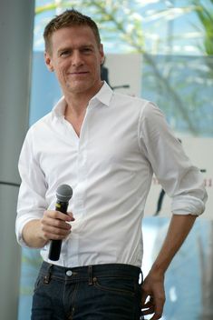 a man in white shirt holding a microphone